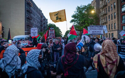 Anti-Zionist protesters with a Hezbollah flag outside a synagogue in New York City, May 11, 2026. (Luke Tress/Times of Israel)