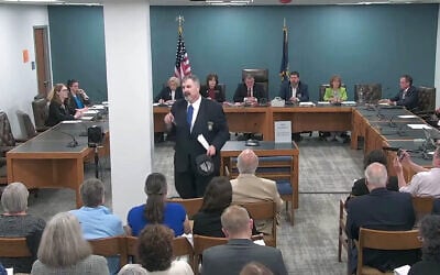 New Hampshire GOP state Rep. Travis Corcoran (center) walks out of his own disciplinary hearing for tweeting a "final solution" reference at a Jewish colleague, April 27, 2026. (Screenshot via JTA)
