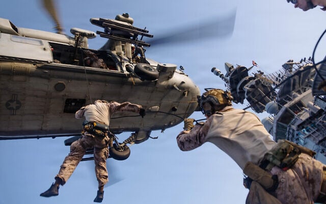 This photo released on May 12, 2026 shows US Marines with Maritime Raid Force rappelling out of an MH-60S Sea Hawk, assigned to Helicopter Sea Combat Squadron 25, during helicopter and roping sustainment training aboard the forward-deployed amphibious assault ship USS Tripoli at sea on May 8, 2026. (US Marine Corps photo) This photo released on May 12, 2026 shows US Marines with Maritime Raid Force rappelling out of an MH-60S Sea Hawk, assigned to Helicopter Sea Combat Squadron 25, during helicopter and roping sustainment training aboard the forward-deployed amphibious assault ship USS Tripoli at sea on May 8, 2026. (US Marine Corps photo)