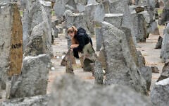 A Polish scout lights a candle in front of the monument of Treblinka World War II-era Nazi death camp on October 2, 2013 in Treblinka. (JANEK SKARZYNSKI / AFP)
