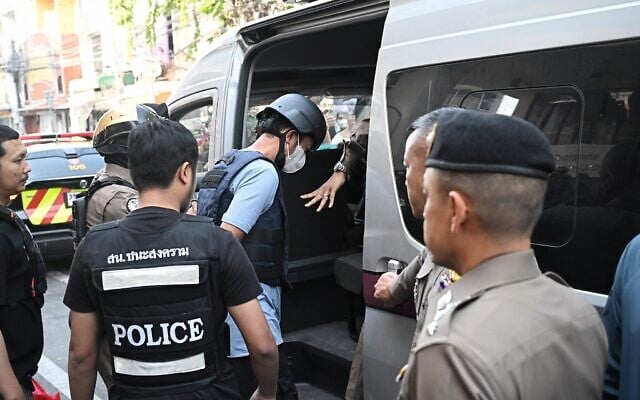 Illustrative: Thai police escort a suspect into a van, Bangkok, Thailand, January 13, 2025. (Lillian SUWANRUMPHA / AFP) Illustrative: Thai police escort a suspect into a van, Bangkok, Thailand, January 13, 2025. (Lillian SUWANRUMPHA / AFP)