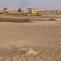 Illustrative: Bulldozers clear sand dunes and extract clay in the desert south of Samawah, Iraq, December 21, 2025. (AHMAD AL-RUBAYE / AFP)