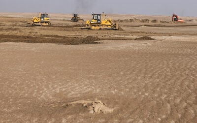 Illustrative: Bulldozers clear sand dunes and extract clay in the desert south of Samawah, Iraq, December 21, 2025. (AHMAD AL-RUBAYE / AFP)