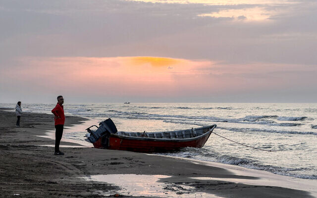 A man stands near a boat moored along a beach on the Caspian Sea coast in Sorkhrud in Iran's northern Mazandaran province on March 24, 2026. (ATTA KENARE / AFP) A man stands near a boat moored along a beach on the Caspian Sea coast in Sorkhrud in Iran's northern Mazandaran province on March 24, 2026. (ATTA KENARE / AFP)