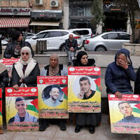 Demonstrators hold placards bearing portraits of Palestinians detained by Israel during a solidarity protest in Ramallah on April 7, 2026. (Zain JAAFAR / AFP)