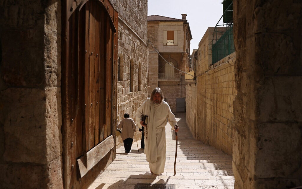 A pilgrim walks outside the Church of the Holy Sepulchre in the Old City of Jerusalem on May 3, 2026. (HAZEM BADER / AFP)