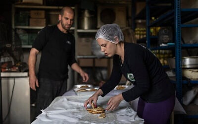 Shina Shabso and her husband Itzik prepare cheese pastries for a wedding in the Circassian village of Rehaniya in northern Israel, near the border with Lebanon, on April 30, 2026. (Ilia YEFIMOVICH / AFP)