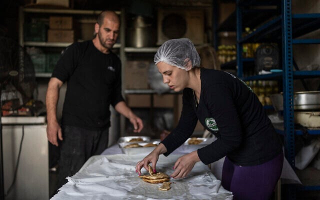 Shina Shabso and her husband Itzik prepare cheese pastries for a wedding in the Circassian village of Rehaniya in northern Israel, near the border with Lebanon, on April 30, 2026. (Ilia YEFIMOVICH / AFP)