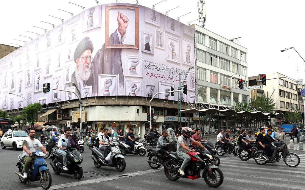 Iranians drive past a huge billboard carrying the image of the slain Iranian supreme leader Ali Khamenei, killed in February 2026 in a military attack by the US and Israel on Iran, in a street in Tehran on May 5, 2026. (AFP)