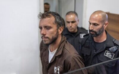 Brazilian activist Thiago Avila is escorted into the Ashkelon Magistrate's Court on May 5, 2026. (Ilia YEFIMOVICH / AFP)