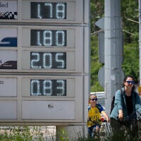 People ride bicycles past a digital board displaying fuel prices near a gas station in Sofia, Bulgaria, on May 6, 2026. (Nikolay DOYCHINOV/AFP)