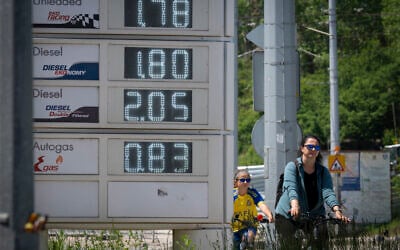 People ride bicycles past a digital board displaying fuel prices near a gas station in Sofia, Bulgaria, on May 6, 2026. (Nikolay DOYCHINOV/AFP)