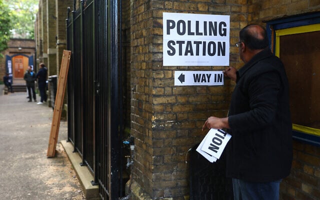 A man puts up 'polling station' signs at a makeshift polling station set up at St John's Parish Hall in central London on May 7, 2026, as polls open for local elections. (Peter Nicholls / AFP) A man puts up 'polling station' signs at a makeshift polling station set up at St John's Parish Hall in central London on May 7, 2026, as polls open for local elections. (Peter Nicholls / AFP)