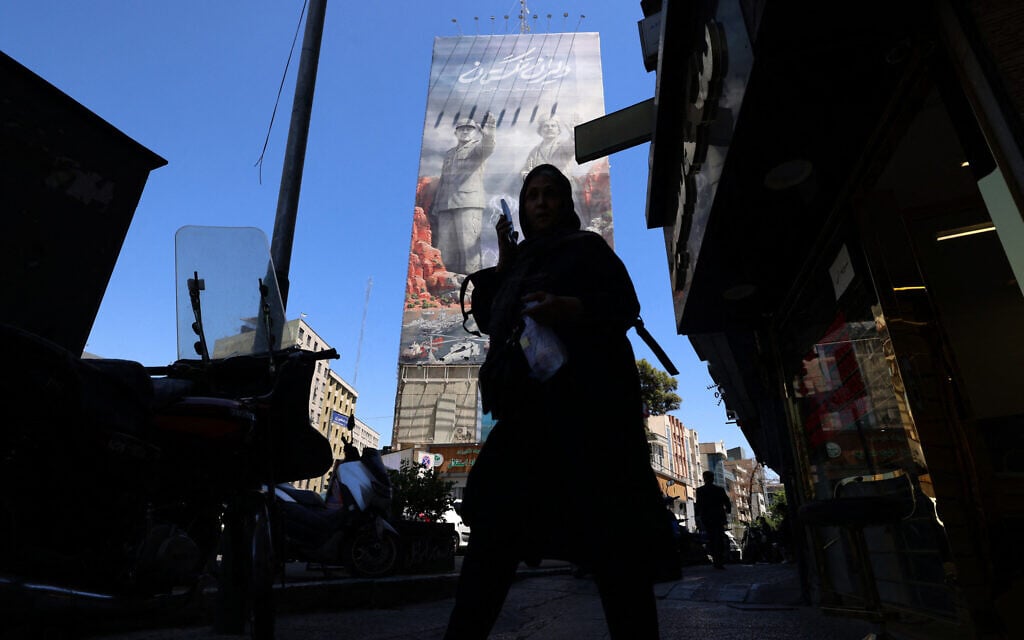 A woman walks along a busy street near a huge mural painted on the side of a building referring to the Strait of Hormuz, in the capital Tehran on May 9, 2026. (Atta Kenare/AFP) A woman walks along a busy street near a huge mural painted on the side of a building referring to the Strait of Hormuz, in the capital Tehran on May 9, 2026. (Atta Kenare/AFP)