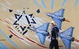 An Iranian woman walks past an anti-US and anti-Israel mural painted on a wall in the capital Tehran on May 10, 2026. (Atta Kenare/AFP)