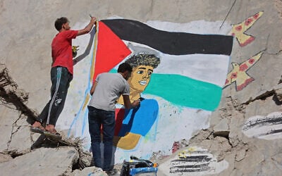 Palestinian artists paint a mural depicting soccer player Lamine Yamal waving a Palestinian flag during Barcelona's title parade, on the rubble of buildings destroyed during the war, at Shati camp in Gaza City on May 13, 2026. (Omar AL-QATTAA / AFP)