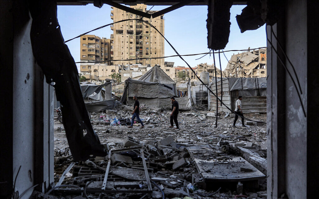 People walk outside a residential building that was hit by an Israeli strike the previous day in the Rimal neighborhood of Gaza City on May 16, 2026. (Omar AL-QATTAA / AFP) People walk outside a residential building that was hit by an Israeli strike the previous day in the Rimal neighborhood of Gaza City on May 16, 2026. (Omar AL-QATTAA / AFP)