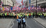 Police officers stand in front of supporters of British far-right activist Tommy Robinson, real name Stephen Yaxley-Lennon, during the 'Unite The Kingdom' rally in central London on May 16, 2026. (Toby Shepheard / AFP)