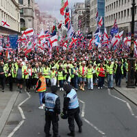 Police officers stand in front of supporters of British far-right activist Tommy Robinson, real name Stephen Yaxley-Lennon, during the 'Unite The Kingdom' rally in central London on May 16, 2026. (Toby Shepheard / AFP)