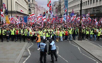 Police officers stand in front of supporters of British far-right activist Tommy Robinson, real name Stephen Yaxley-Lennon, during the 'Unite The Kingdom' rally in central London on May 16, 2026. (Toby Shepheard / AFP)