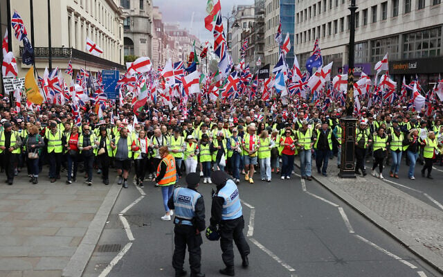 Police officers stand in front of supporters of British far-right activist Tommy Robinson, real name Stephen Yaxley-Lennon, during the 'Unite The Kingdom' rally in central London on May 16, 2026. (Toby Shepheard / AFP) Police officers stand in front of supporters of British far-right activist Tommy Robinson, real name Stephen Yaxley-Lennon, during the 'Unite The Kingdom' rally in central London on May 16, 2026. (Toby Shepheard / AFP)