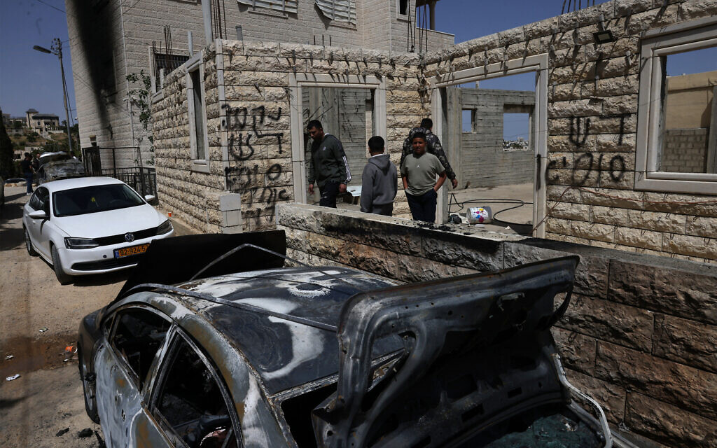 Palestinians inspect destroyed vehicles outside their home hours after settlers allegedly set fire to two vehicles and scrawled Hebrew graffiti on the walls in Halhul, north of Hebron, on May 20, 2026 (HAZEM BADER / AFP) Palestinians inspect destroyed vehicles outside their home hours after settlers allegedly set fire to two vehicles and scrawled Hebrew graffiti on the walls in Halhul, north of Hebron, on May 20, 2026 (HAZEM BADER / AFP)