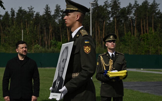 Ukraine's President Volodymyr Zelensky (L) attends the reburial ceremony of Nazi collaborator Andriy Melnyk, who died in 1964 and was the leader of a branch of the Organisation of Ukrainian Nationalists (OUN), along with his wife Sofia, at the National Military Memorial Cemetery near Kyiv on May 25, 2026 (Photo by Genya SAVILOV / AFP)
