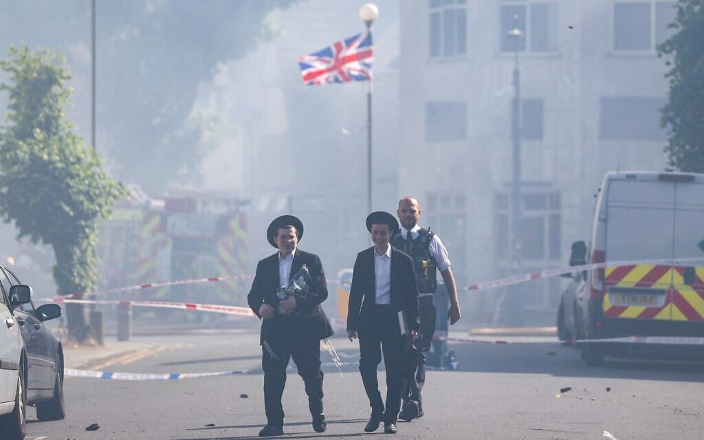 Local residents walk past a cordoned area where a fire broke out at a kosher supermarket in the Golders Green neighborhood in north London on May 27, 2026 (Toby Shepheard / AFP)