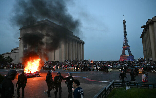 A car is set ablaze as PSG supporters celebrate their soccer team's win in the UEFA Champions League final between Paris Saint-Germain (PSG) and Arsenal FC played in Budapest, at Place du Trocadero opposite the Eiffel Tower in Paris on May 30, 2026. (LOU BENOIST / AFP)