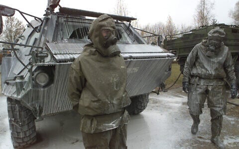 German Army soldiers next to a 'Fuchs' nuclear, biological and chemical detection tank covered with a decontamination liquid after a drill at the General Jaeger barracks in Sonthofen, southern Germany, November 19, 2001. (AP Photo/Diether Endlicher)