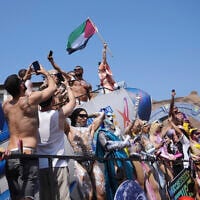 People hoist a Palestinian flag during a Pride parade in Rome, on June 14, 2025. (AP Photo/Alessandra Tarantino)