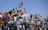 People hoist a Palestinian flag during a Pride parade in Rome, Italy, on June 14, 2025. (AP Photo/Alessandra Tarantino)