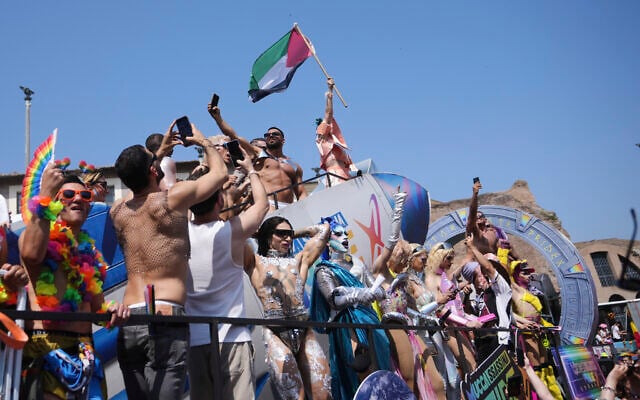People hoist a Palestinian flag during a Pride parade in Rome, Italy, on June 14, 2025. (AP Photo/Alessandra Tarantino)