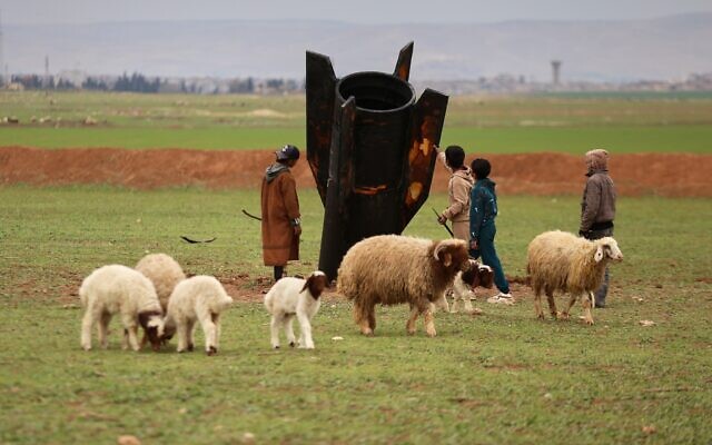 Exposing themselves to the danger of unexploded ordnance, shepherd boys inspect an unexploded Iranian projectile that landed in an open field on the outskirts of Qamishli, eastern Syria, March 4, 2026. (AP/Baderkhan Ahmad) Exposing themselves to the danger of unexploded ordnance, shepherd boys inspect an unexploded Iranian projectile that landed in an open field on the outskirts of Qamishli, eastern Syria, March 4, 2026. (AP/Baderkhan Ahmad)