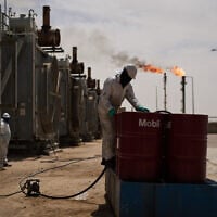 Illustrative: A worker collects engine oil as he works at a degassing station in the Zubair oil field near Basra, Iraq, on March 28, 2026. (AP Photo/Leo Correa)
