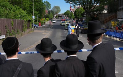 Members of the Jewish community watch as forensic officers search the area after two people were stabbed in north London's Golders Green neighborhood, on April 29, 2026. (AP Photo/Kin Cheung)