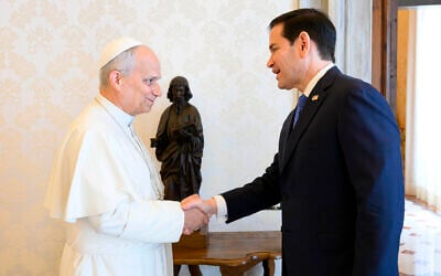 Pope Leo XIV, left, greets US Secretary of State Marco Rubio upon his arrival for talks in the pope's private library at the Vatican, May 7, 2026. (Vatican Media via AP)