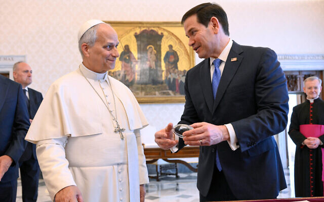 In this handout photo provided by Vatican Media Pope Leo XIV exchanges gifts with US Secretary of State Marco Rubio, right, as they meet in the pope's private library at the Vatican, May 7, 2026. (Vatican Media via AP)