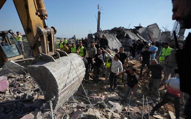 Rescue workers search for survivors using heavy machinery through the rubble of houses damaged by an Israeli airstrike in the village of Saksakieh, southern Lebanon, Saturday, May 9, 2026. (AP Photo/Mohammed Zaatari)