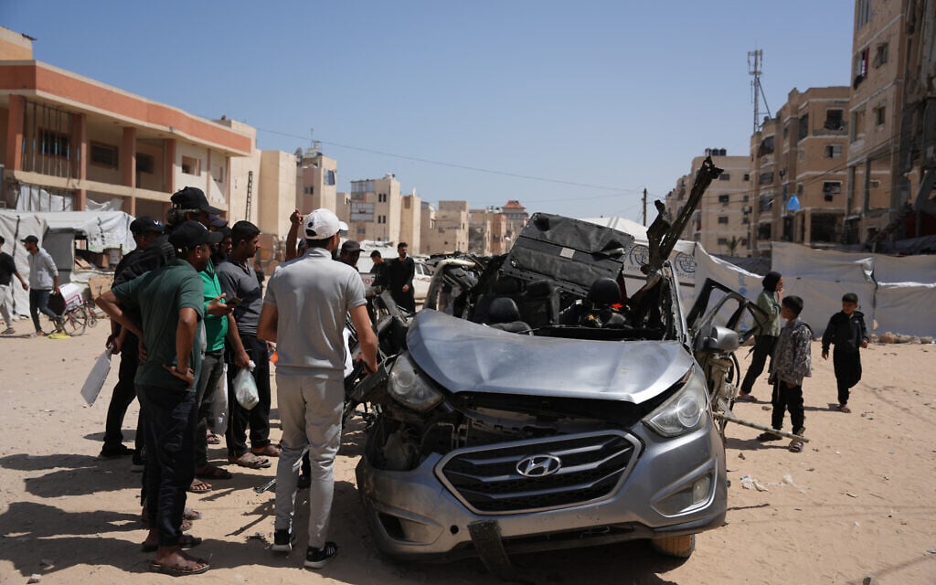 Palestinians inspect a vehicle struck by an Israeli airstrike in Khan Younis, in the southern Gaza Strip, May 10, 2026. (AP Photo/Abdel Kareem Hana)