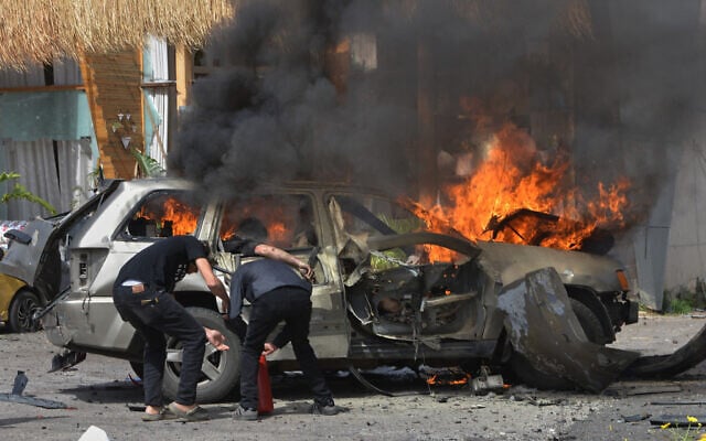 A person is seen inside a burning vehicle as men attempt to put out the fire after an airstrike hit a car in the coastal town of Barja, south of Beirut, Lebanon, on May 13, 2026. (AP Photo/Mustafa Jamalddine) A person is seen inside a burning vehicle as men attempt to put out the fire after an airstrike hit a car in the coastal town of Barja, south of Beirut, Lebanon, on May 13, 2026. (AP Photo/Mustafa Jamalddine)