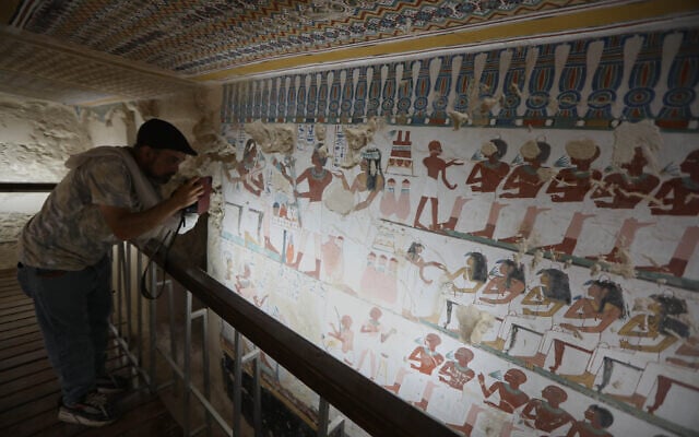 A visitor films at the tomb of Samut, door keeper of Amun during the 18th Dynasty, after restorations help by the Zahi Hawass Foundation for Heritage and Antiquities in Luxor, Egypt, May 14, 2026. (AP Photo)