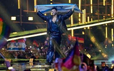 Noam Bettan from Israel walks onto the stage carrying his country's flag ahead of the Grand Final of the 70th Eurovision Song Contest in Vienna, Austria, May 16, 2026. (AP/Martin Meissner)