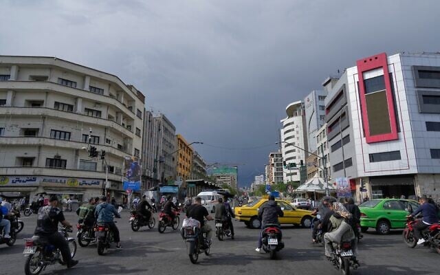 Motorbikes and cars pass through an intersection in downtown Tehran, Iran, May 17, 2026. (AP/Vahid Salemi)