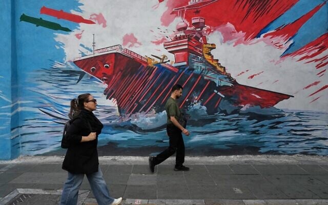 People walk past a mural depicting a US aircraft carrier under missile attack in downtown Tehran, Iran, May 17, 2026. (AP Photo/Vahid Salemi) People walk past a mural depicting a US aircraft carrier under missile attack in downtown Tehran, Iran, May 17, 2026. (AP Photo/Vahid Salemi)