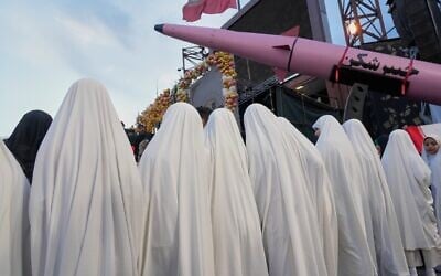 A group of girls stand beside a "Khaybar-buster" missile during a mass wedding ceremony for couples participating in the "Janfada" ("Sacrifice for Iran") pro-government campaign in Tehran, on May 18, 2026. (AP Photo/Vahid Salemi)