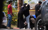People embrace near the scene of a shooting outside the Islamic Center of San Diego Monday, May 18, 2026, in San Diego. (AP Photo/Gregory Bull)