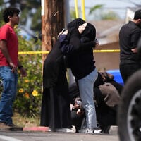 People embrace near the scene of a shooting outside the Islamic Center of San Diego Monday, May 18, 2026, in San Diego. (AP/Gregory Bull)