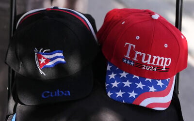 A vendor sells caps supporting Cuba and US President Donald Trump Trump, as a small group of Cubans gather to hold signs and wave flags hours after federal prosecutors announced charges against former Cuban President Raul Castro, May 20, 2026, in Miami, Florida. (AP Photo/Rebecca Blackwell)