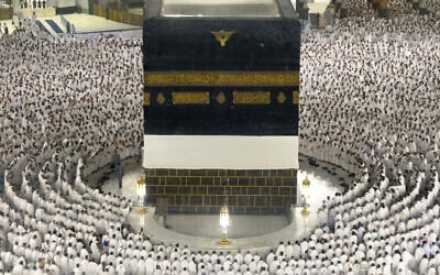 In this photograph taken through a glass fence, Muslim pilgrims are seen praying around the Kaaba, Islam's holiest site, at the Grand Mosque in Mecca, Saudi Arabia, during the annual Hajj pilgrimage, on May 22, 2026. (AP Photo/Altaf Qadri)